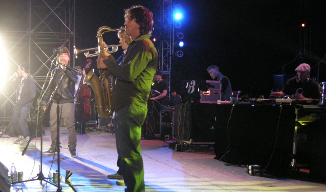 Us3 onstage in Century Park, Shanghai (China). From left to right: Akil Dasan, Brook Yung, Chris Dodd (double bass), Bryan Corbett (trumpet), Ed Jones (sax), Sean Hargreaves (keyboards), Geoff Wilkinson (beats), DJ First Rate (turntables).